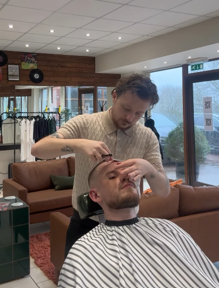 Ewan performing a traditional razor shave on a client at REFINED